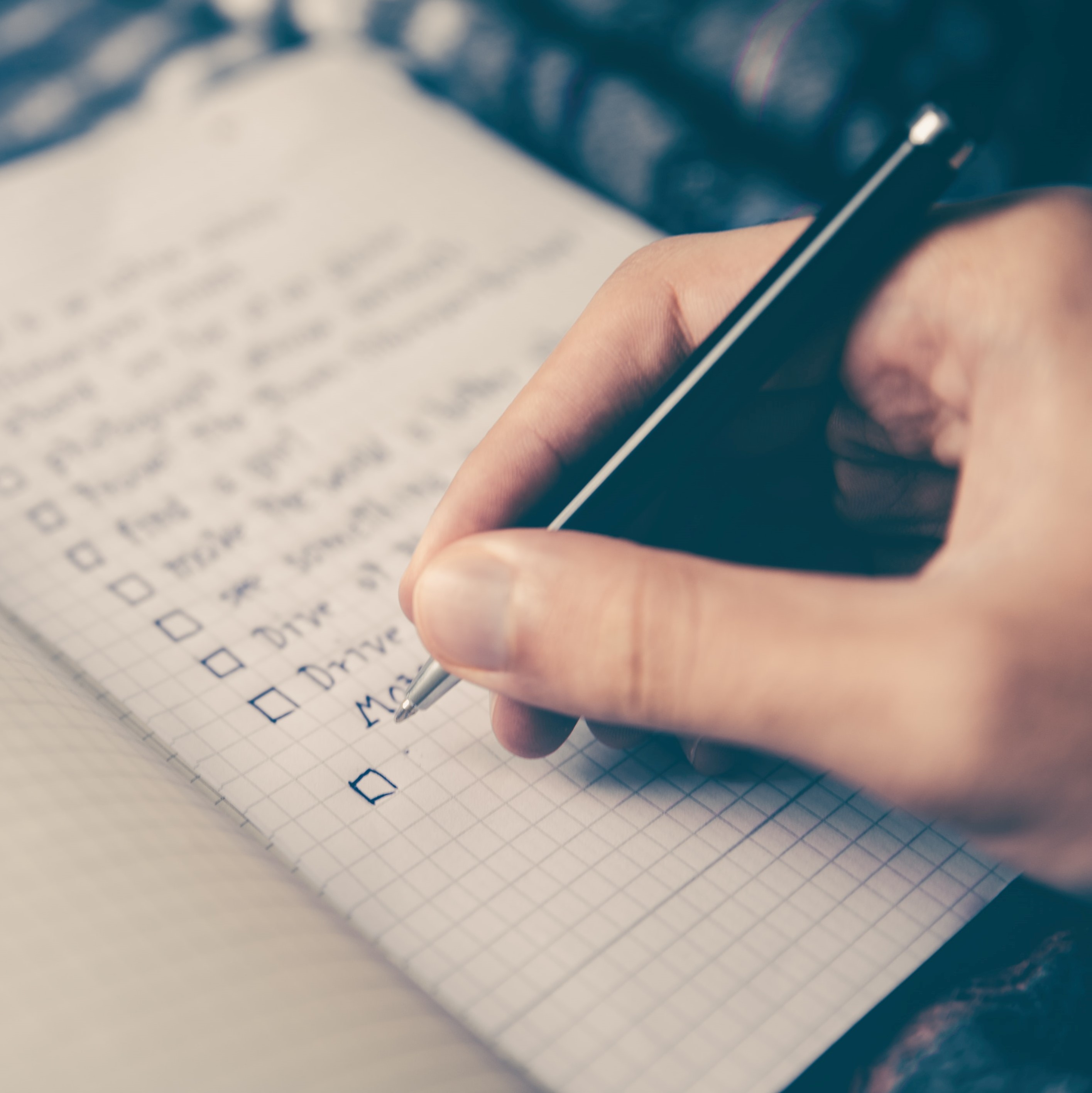 Picture of a person writing a checklist in a journal