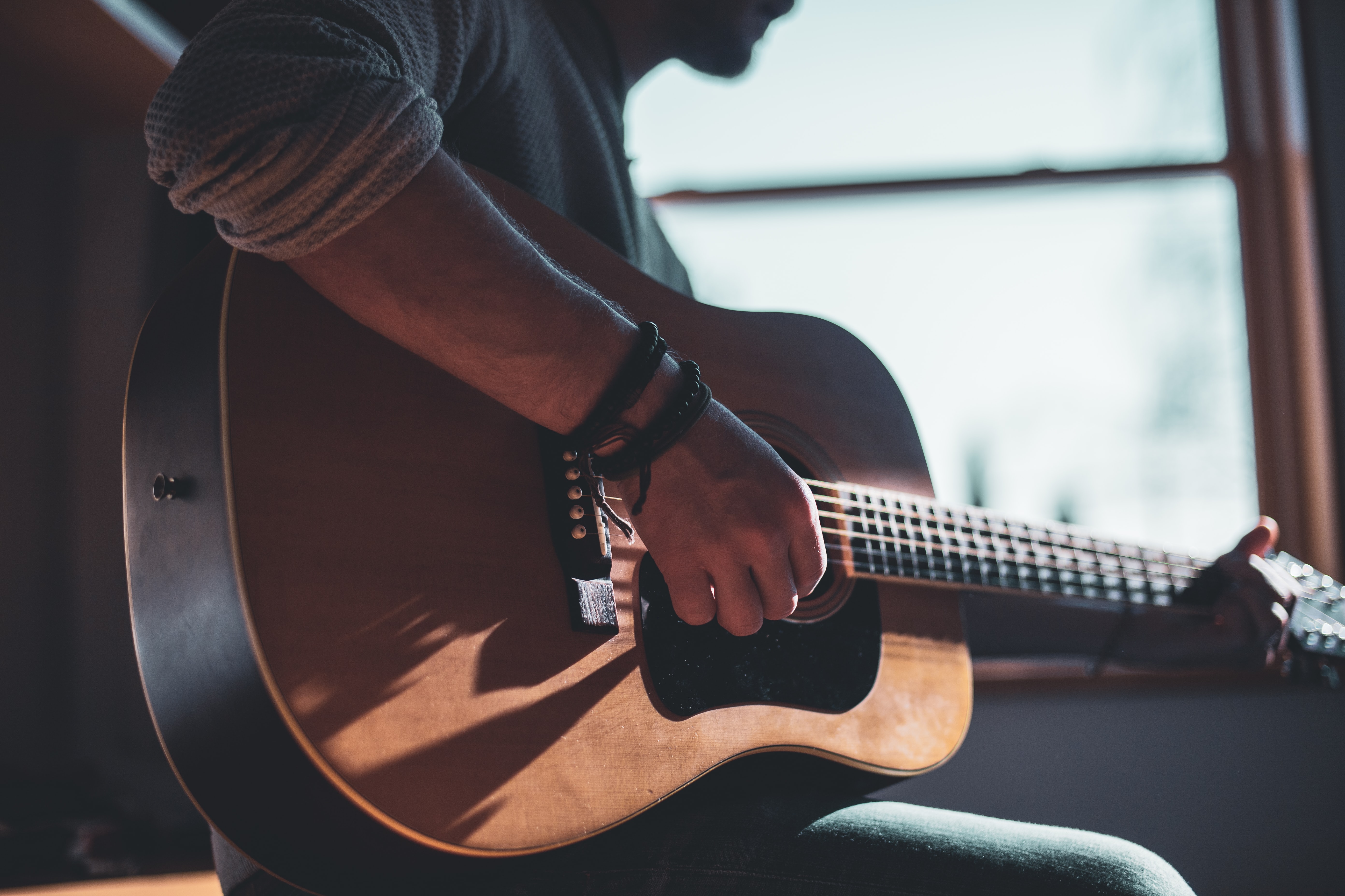 Close up image of a man playing guitar.